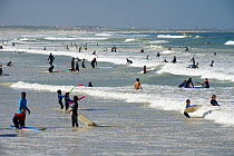 Crowd of people at Surfers Corner, Muizenberg Beach, False Bay, near Cape Town, Western Cape, South Africa.  July.