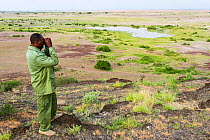 Joel Cheruiyot, Tortilis Camp guide looks for wildlife with his binoculars. Amboseli National Park, Kenya.