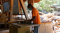 Man working in a workshop in a sustainable timber yard, Mezimbite Sustainable Forest Camp, Mozambique, 2014.