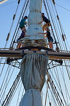 Crew attending to sails on mast of a sailing boat, Sargasso Sea, Bermuda