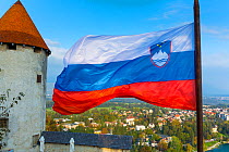 Bled Castle with the Slovenian flag, Bled, Slovenia, October 2014.