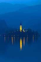 Assumption of Mary Pilgrimage Church, in twilight, reflected in Lake Bled, Bled, Slovenia, October 2014.