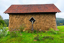Old Barn, with crucifix outside, near Lake Cerknika, Green Karst, Slovenia, October 2014