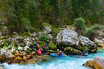 Kayakers starting off from bank of the Soca river, Soca Valley, Julian Alps, Bovec, Slovenia, October 2014.