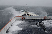 Waves break over the bow of the Clipper Adventurer, a polar expedition ship, during a foggy crossing of the rough Drake Passage, November 2007.
