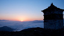 Sunrise from a mountain summit, with a Buddhist monastery in the foreground, Himalayas, Bhutan, May 2015.