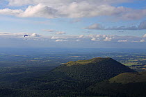 Paraglider flying over Puy Pariou Volcano,  Auvergne, Puy-de-dome, France, August.