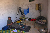 Italian photographer Bruno D'Amicis waiting for sandstorm to pass in concrete hut in the desert. on assignment to photograph Fennec foxes (Vulpes zerda) Tunisia, May 2012.