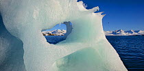 View through glacier ice towards snow-covered mountains in Kongsfjorden fjord in Svalbard, Spitsbergen, Norway.