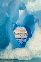 View through glacier ice towards snow-covered mountains in Kongsfjorden fjord in Svalbard, Norway. June 2015.