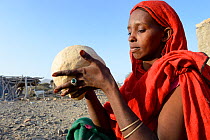 Afar tribe woman kneading a bread loaf before baking it, Malab-Dei village, Danakil depression, Afar region, Ethiopia, March 2015.