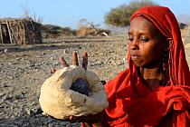 Afar tribe woman baking bread with a hot stone, Malab-Dei village, Danakil depression, Afar region, Ethiopia, March 2015.