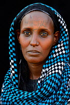 Head portrait of Afar tribe woman with facial tattoos / skin scarifications and wearing head scarf, Malab-Dei village, Danakil depression, Afar region, Ethiopia, March 2015.