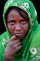 Head portrait of young Afar tribe woman with facial tattoo / skin scarifications and head scarf, Malab-Dei village, Danakil depression, Afar region, Ethiopia, March 2015.