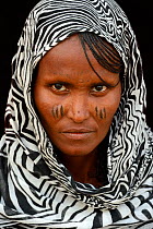 Head portrait of Afar tribe woman with facial tattoos / skin scarification and wearing a head scarf, Ahmed Ela village, Danakil depression, Afar region, Ethiopia, March 2015.