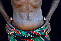 Toposa tribe man with skin scarifications on his belly describing a hunt, Omo Valley, Ethiopia, March 2015.