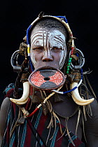 Portrait of woman from the Mursi tribe, traditionally decorated and painted, wearing a large clay lip plate, Omo Valley, Ethiopia, March 2015.