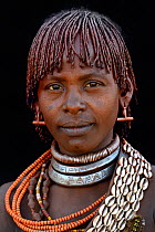 Young Hamer tribe woman with traditional necklaces and hair covered with a mixture of ochre and animal fat, Omo valley, Ethiopia, March 2015.