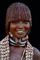 Young Hamer tribe woman with traditional necklaces and hair covered with a mixture of ochre and animal fat, Omo valley, Ethiopia, March 2015.