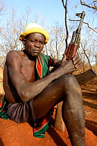 Older man from the Bodi tribe displaying elaborate skin scarifications, and holding Kalashnikov gun. The ones on his shoulder are for enemies he killed, the circles on the arm are for big game he hunt...