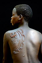 Young woman from the Bodi tribe displaying elaborate scarification on the skin of her back, Omo Valley, Ethiopia, March 2015.