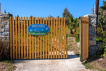 Main gate of the Aegean Wildlife Hospital with sign. Paros Island, Cyclades, Aegean Sea, Mediterranean, Greece.  October 2014