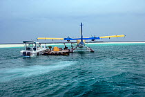 Trans Maldivian hydroplane (seaplane) docked next to a small floating platform, to transport tourists to various islands. Male, Maldives, Indian Ocean, April 2010.