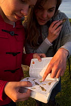 Rita Norvaisaite, from the Baltic Environmental Forum, helping a young girl identify bird, during a bird festival in the Nemunas River Delta, Lithuania, May 2015.