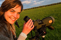 Rita Norvaisaite, from the Baltic Environmental Forum, checking telescope while leading a birdwatching group during a bird festival, Nemunas River Delta, LithuaniaNemunas River Delta, Lithuania, May 2...