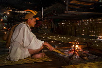 Nyshi man inside Nyshi Long House, Nyshi Tribe, Arunachal Pradesh.North East India, November 2014.