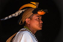 Nyshi man inside Nyshi Long House, Nyshi Tribe, Arunachal Pradesh.North East India, November 2014.