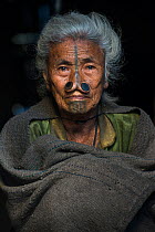 Apatani woman woman with facial tattoos and traditional cane nose plugs / Yapin Hulo made to make them look unattractive to males from other tribes. These facial modifications are now outlawed. Apatan...