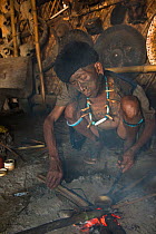 Konyak Naga man preparing opium to smoke. Mon district. Nagaland,  North East India, October 2014.