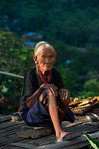 Elderly Konyak Naga woman in traditional dress. Mon district. Nagaland,  North East India, October 2014.