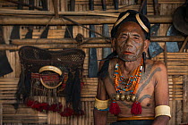 Konyak Naga tattooed chief head hunter with traditional ornamentation of Elephant ivory arm bands and Hornbill headdress. Only someone who has killed and taken a human head can be tattooed in this man...