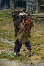 Konyak Naga  girl carrying rice basket on her back, Mon district, Nagaland, North East India, October 2014.
