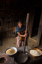 Konyak Naga woman pounding rice, Mon district, Nagaland,  North East India, October 2014.