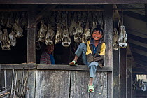 Konyak Naga child outside house with animal skulls, Mon district, Nagaland, North East India, October 2014.