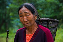 Konyak Naga woman with rice basket, Mon district. Nagaland, North East India, October 2014.