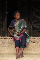 Chang Naga woman and dog, Tuensang district. Nagaland, North East India, October 2014.