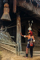 Chang Naga man in festival dress with tiger claws (Panthera tigris) around his face, Hornbill (Bucerotidae) feathers on hat, and Wild boar (Sus scrofa) tusks on hat. Chang Naga headhunting Tribe. Tuen...