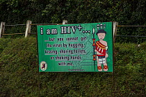 HIV signs awareness sign featuring Ao Naga headhunting tribesman in traditional festival clothing. Nagaland, North East India, October 2014.