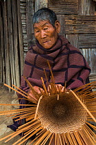 Chang Naga man making basket, Chang Naga man, Tuensang district. Nagaland, North East India, October 2014.