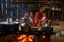Chang Naga family in house with cooking fire, Tuensang district. Nagaland, North East India, October 2014.