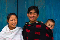 Ao Naga family, with father carrying baby on back, Ao Naga tribe, Nagaland, North East India, October 2014.