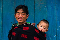 Ao Naga man  carrying baby on back, Ao Naga tribe, Nagaland, North East India, October 2014.