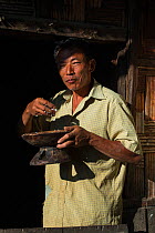 Ao Naga man eating off of tradition plate,  Mokokchung district. Nagaland, North East India, October 2014.