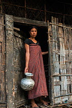 Mising woman holding pot, Majuli Island, Brahmaputra River, Assam, North East India, October 2014.