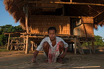 Mising tribe man setting out cane for basket weavings, Majuli Island, Brahmaputra River, Assam, North East India, October 2014.