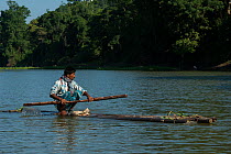 Fisherman on raft, Assam. North East India. October 2014.